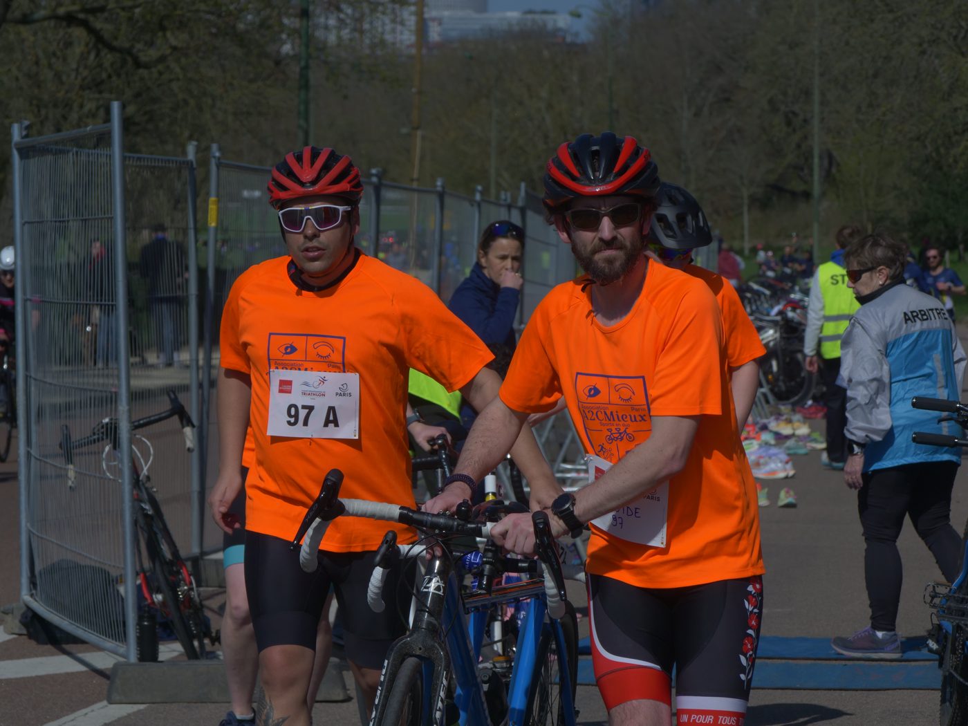 Deux cyclistes A2CMieux casqués avec leur vélo avant un départ.