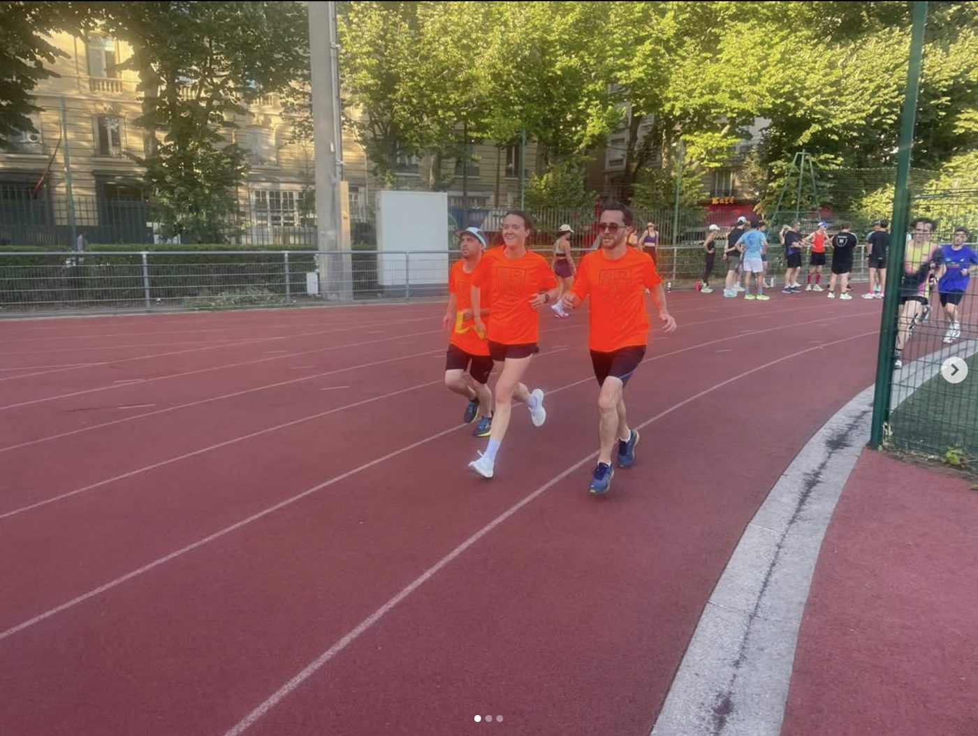 Des coureuses A2CMieux à l'entraînement sur une piste d'athlétisme au crépuscule.
