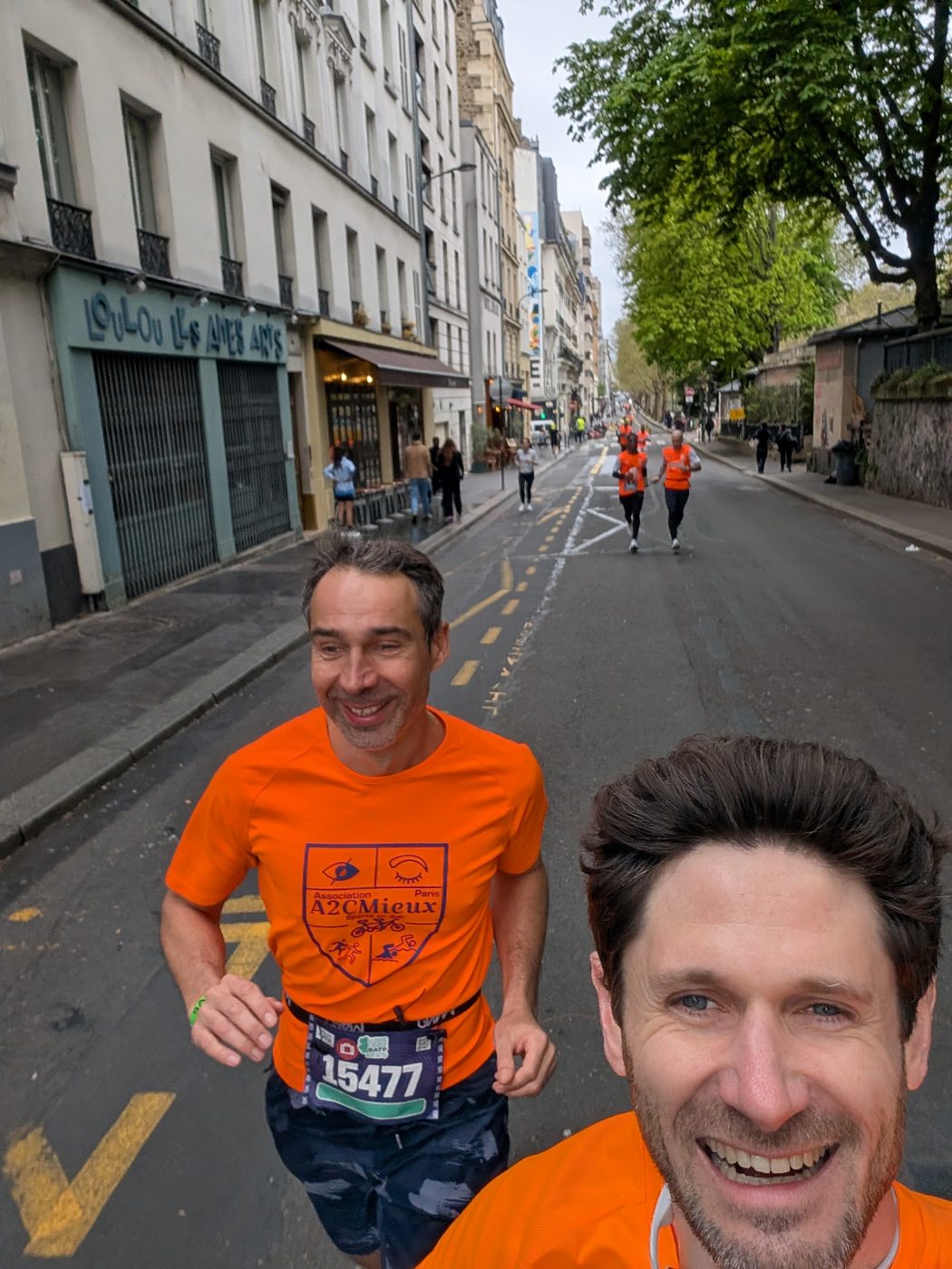 Un coureur A2CMieux tout sourire en selfie pendant une course à Paris.