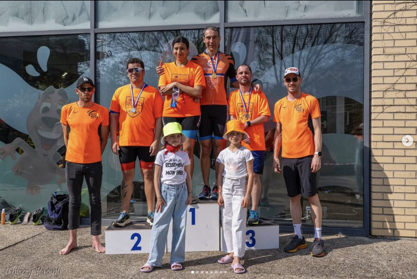 Des membres d'A2CMieux sur un podium de compétition avec de jeunes participants.